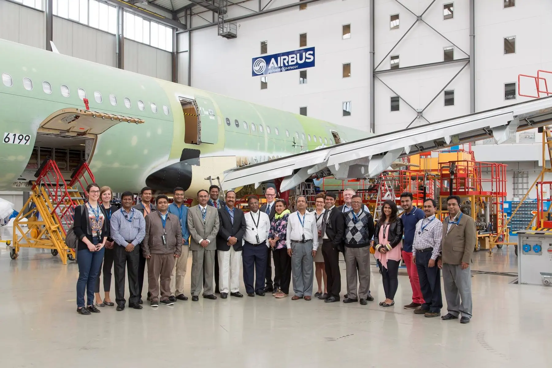 Cyrus with a delegation beside an Airbus aircraft under construction