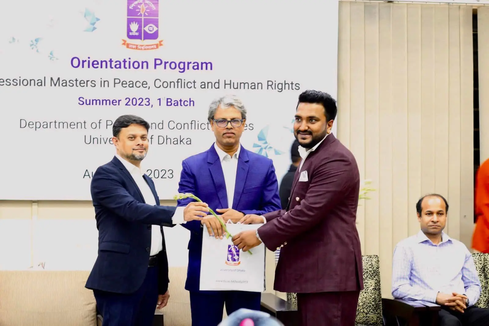 Cyrus receiving a welcome pack during a University of Dhaka orientation programme
